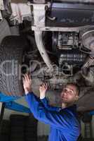 Happy mechanic under car