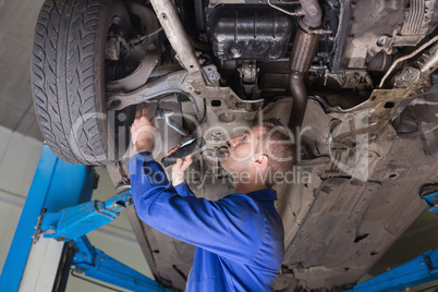 Repairman examining under car