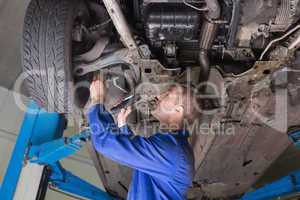 Repairman examining under car