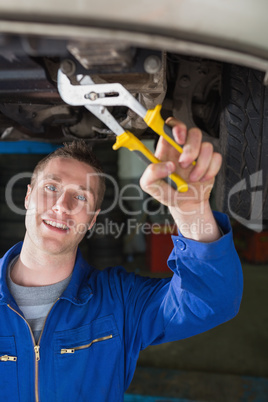 Mechanic repairing car with pliers