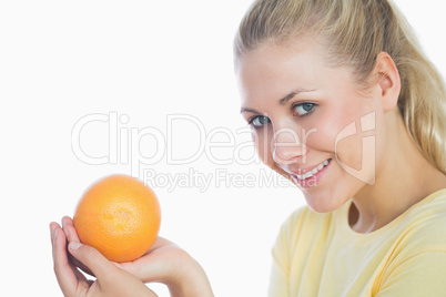 Happy woman holding orange