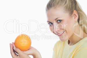 Happy woman holding orange