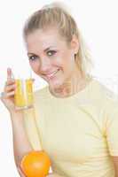 Happy woman holding juice and orange