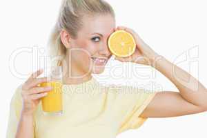 Happy woman with glass of juice and slice of orange