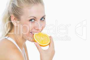 Happy woman biting slice of orange
