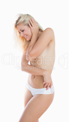 Topless young woman in panties smiling