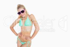 Young woman in bikini wearing sunglasses