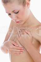 Naked woman examining breast