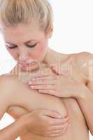 Naked woman examining her breast