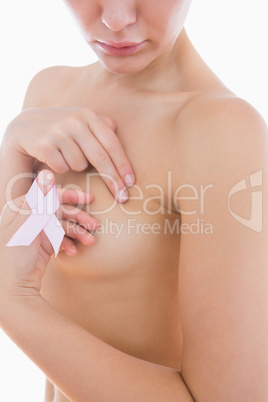 Naked woman holding breast cancer ribbon