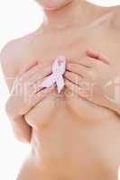 Woman holding breast cancer ribbon over breasts