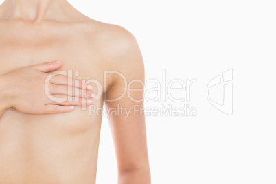 Naked woman covering her breast with hand