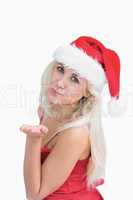 Woman wearing santa hat as she blows kiss