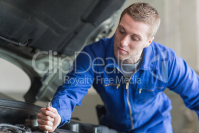 Auto mechanic working on car
