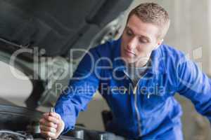 Auto mechanic working on car