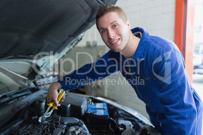 Male mechanic fixing car engine