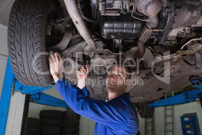 Auto mechanic working under car