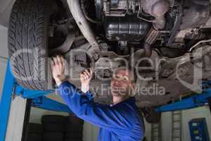 Auto mechanic working under car