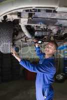 Male car mechanic examining vehicle