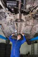 Auto mechanic examining car