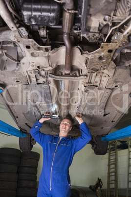 Portrait of mechanic working under car