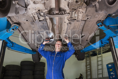 Mechanic inspecting under car