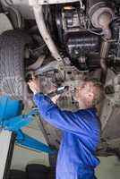 Auto mechanic examining under car