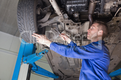 Male mechanic repairing car