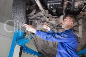 Male mechanic repairing car