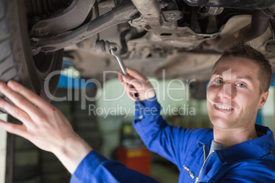 Portrait of mechanic working under car