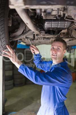 Mechanic in coveralls working under car