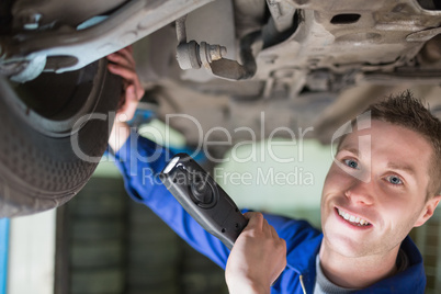 Portrait of mechanic examining tire