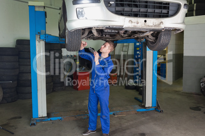 Repairman working under raised car