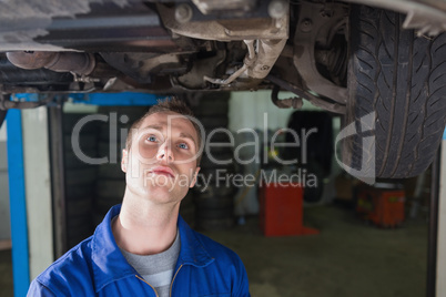 Repairman standing under car