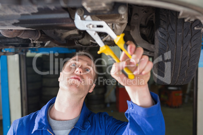 Mechanic repairing car with adjustable pliers