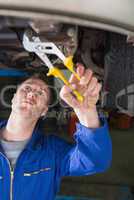 Mechanic repairing car with pliers