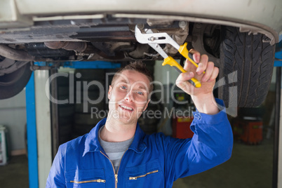 Mechanic repairing car with adjustable pliers