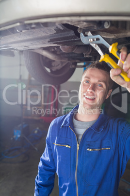 Happy male mechanic repairing car