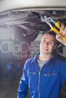 Happy male mechanic repairing car