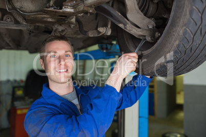 Mechanic repairing car with spanner