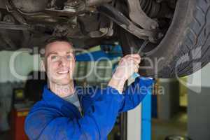 Mechanic repairing car with spanner