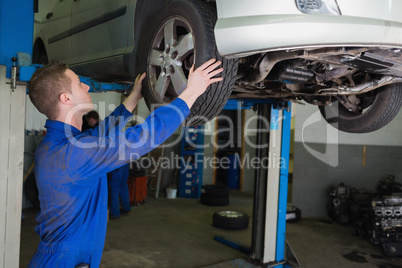 Auto mechanic examining car tire