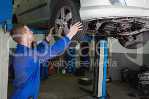 Auto mechanic examining car tire