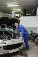 Male mechanic repairing car