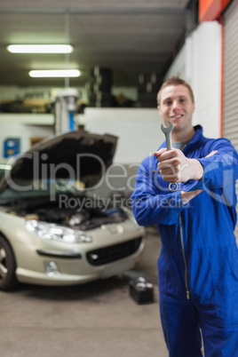 Male mechanic showing spanner