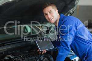 Male mechanic holding tablet pc