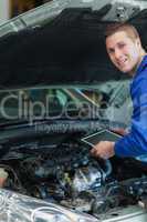 Happy mechanic holding tablet pc