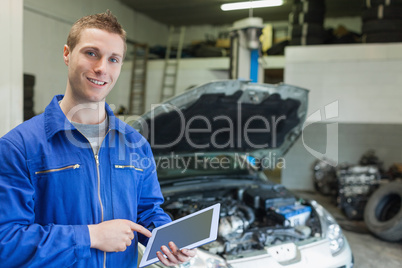 Happy mechanic using digital tablet