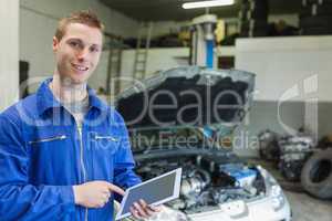 Happy mechanic using digital tablet
