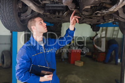 Mechanic examining under car